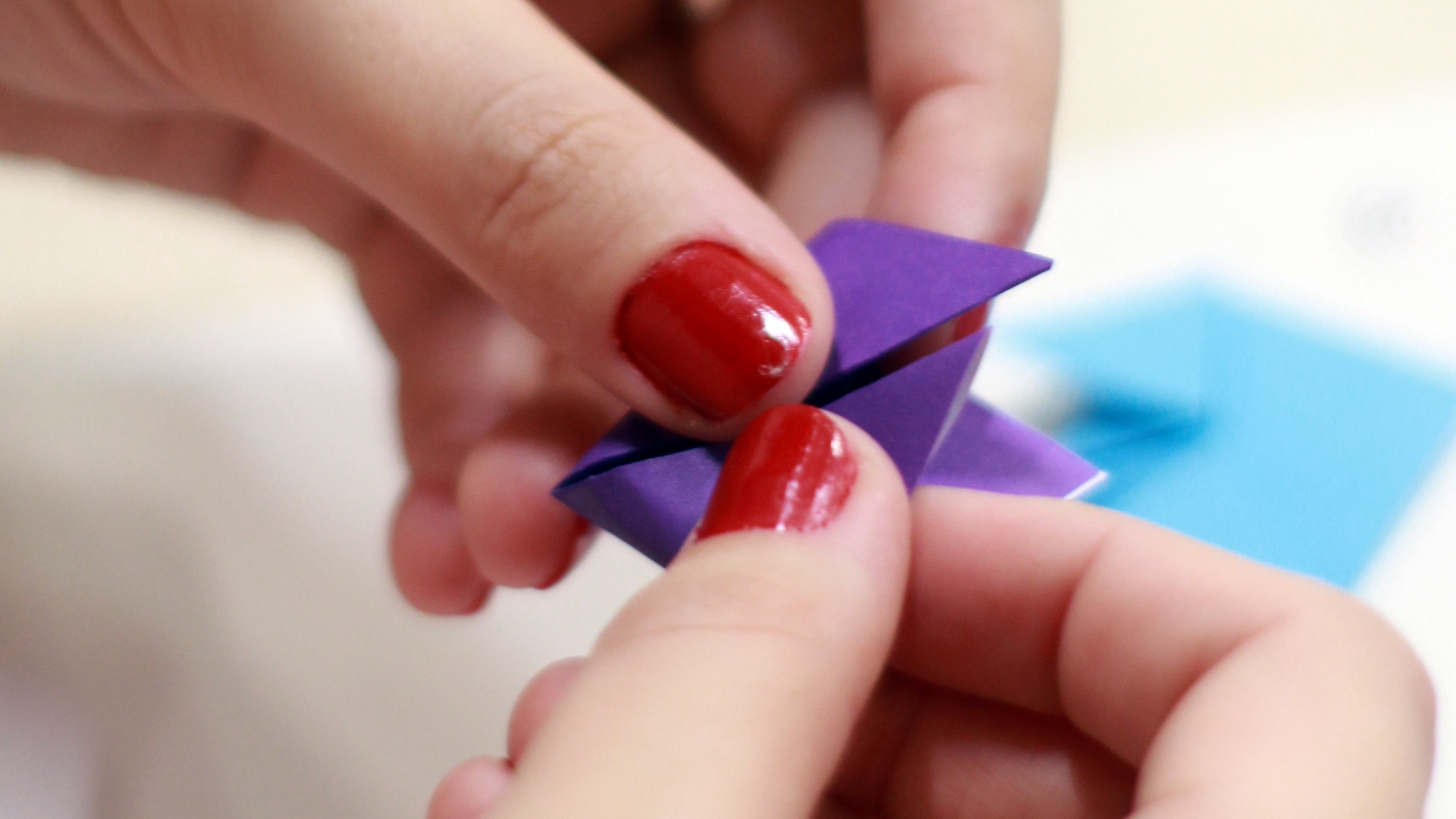 Photo of someone's hands holding a purple origami shape