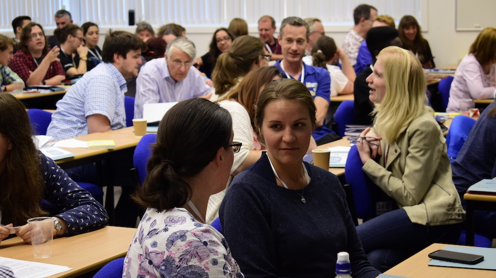 Photo of a room of people talking to each other