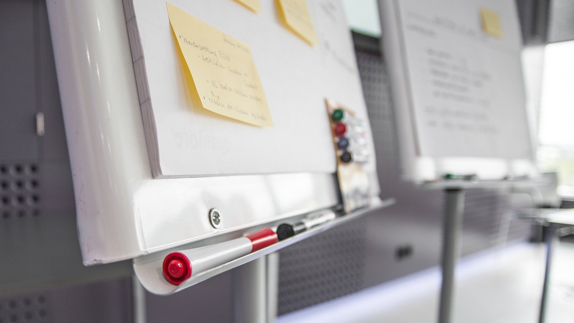 Close-up photo of a whiteboard with some pens on the front shelf